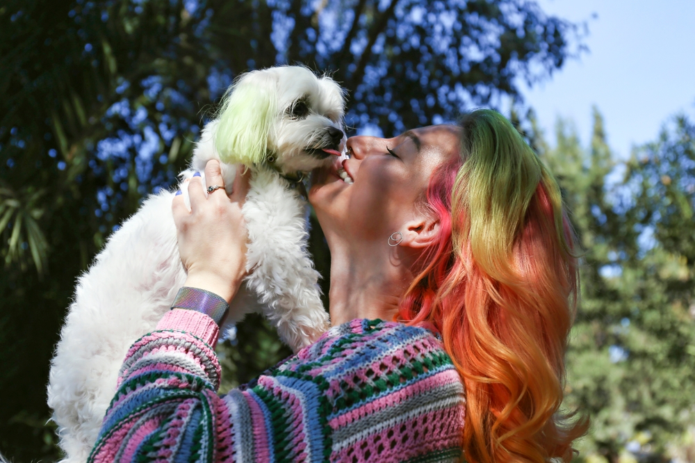 Young woman with Miniature Schnauzer dog outdoors