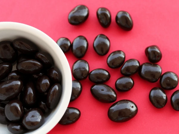 A bowl of chocolate-covered raisins, a type of candy that is toxic for dogs and cats